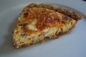 A slice of bacon ranch quiche served on a white plate.