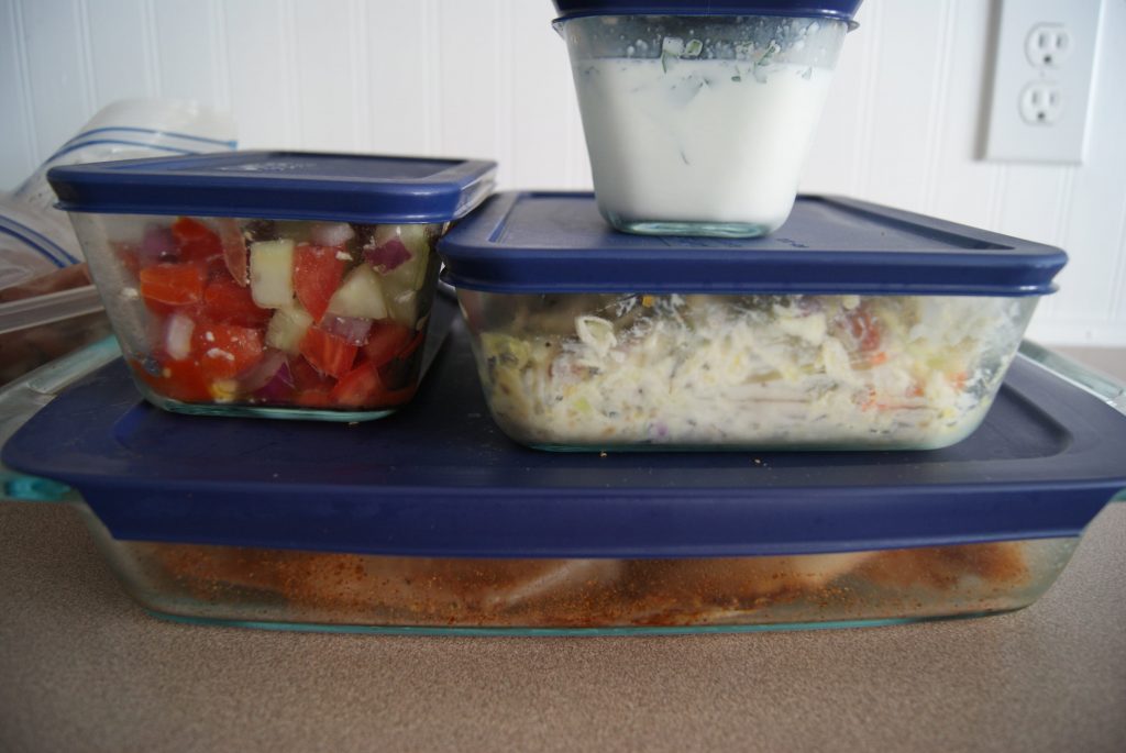 Prepped meals in glass storage containers ready to be stored.