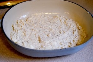 Baking mix, butter, and milk, mixed together in a blue bowl.