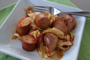 Baked Sausage and cabbage served on a white plate.