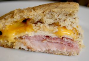 A slice of baked monte cristo, served on a white plate.