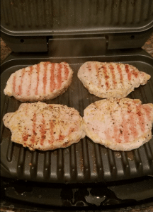 Turkey patties cooking on a George Forman grill.
