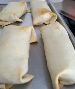 Toasted black bean chimichangas on a baking sheet.