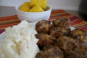 Honey Meatloaf served with a side of mashed potatoes and a bowl of petite ears of corn.