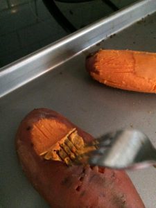 oven roasted sweet potato being sliced with a fork.