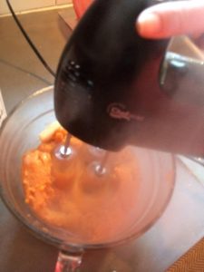 Sweet potatoes being mixed with a mixer to give the the mashed potato affect.