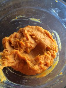 Mashed, and whipped sweet potatoes in a clear bowl.