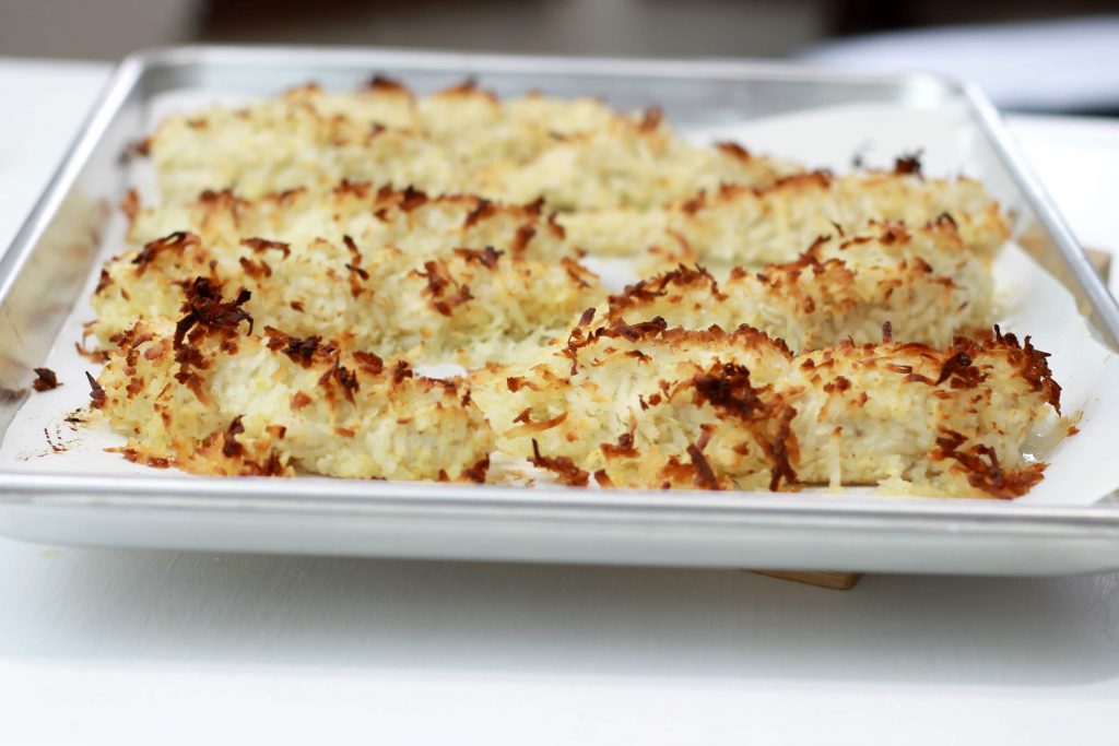 Cooked chicken strips, topped with coconut shaves, all cooked and in one pan.