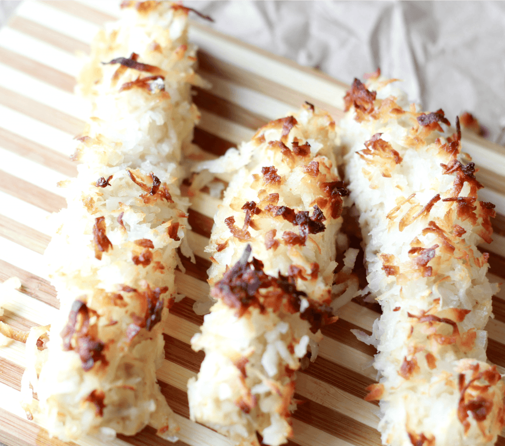 Cooked coconut chicken strips placed on plate ready to be served.