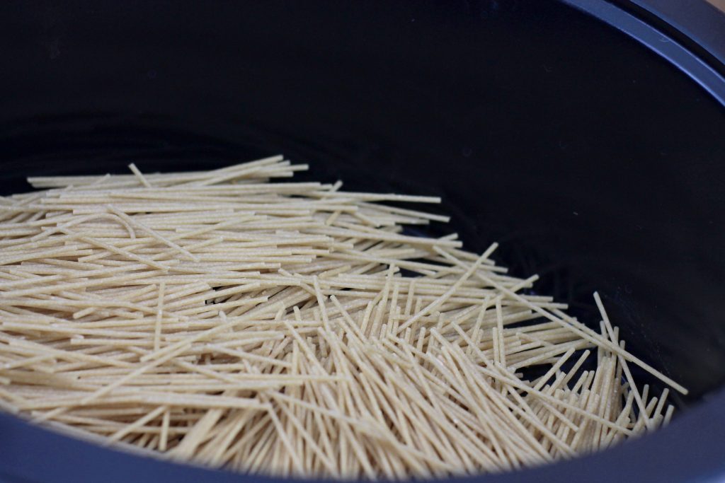Gluton free multi grain spaghetti pasta in a crock pot ready to be cooked.