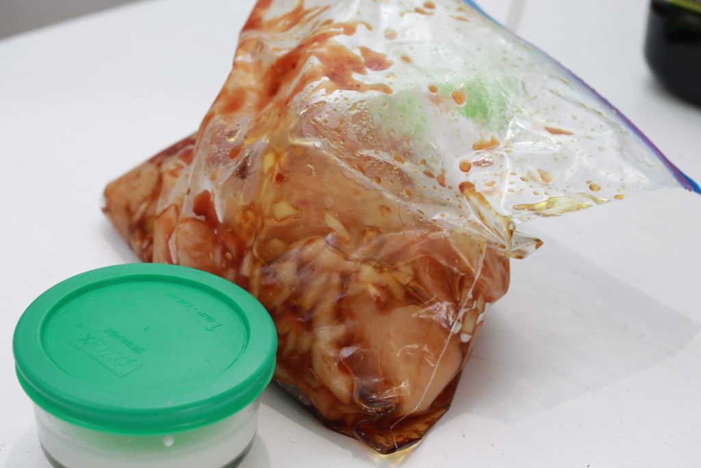 Uncooked chicken marinating with honey and soy sauce in a clear plastic bag ready to be prepared.