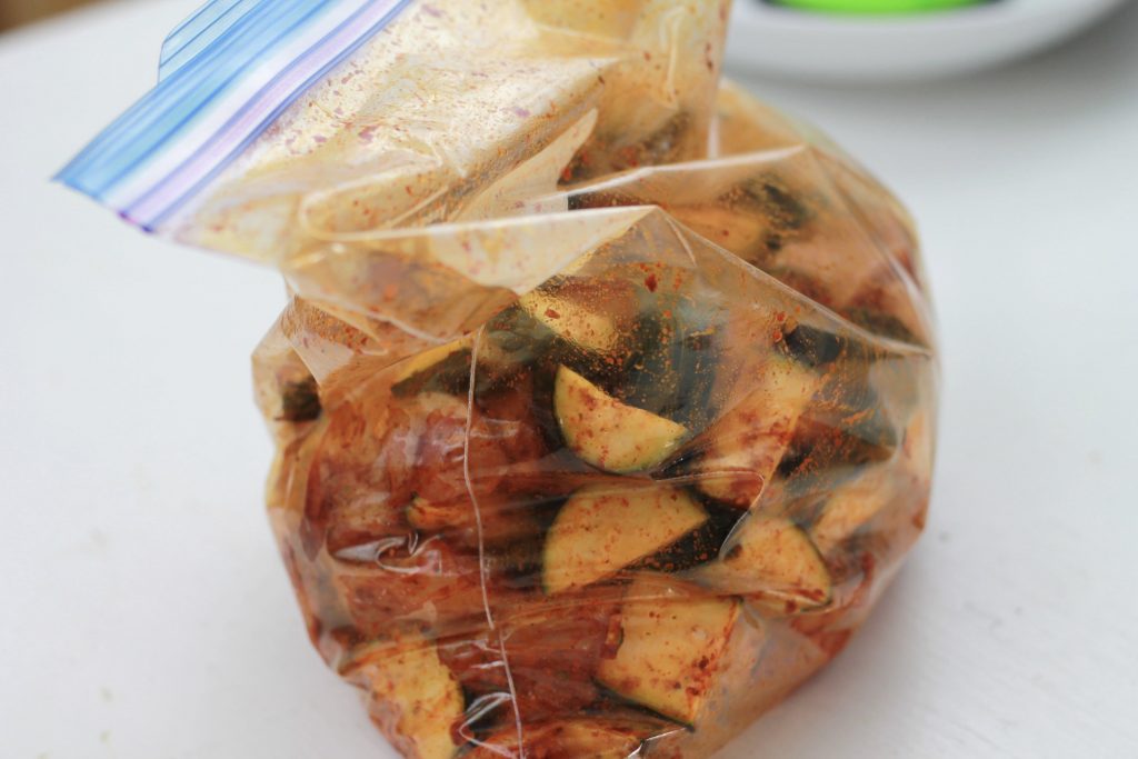 Cucumber, chicken, and spices all mixed together in a clear plastic bag.