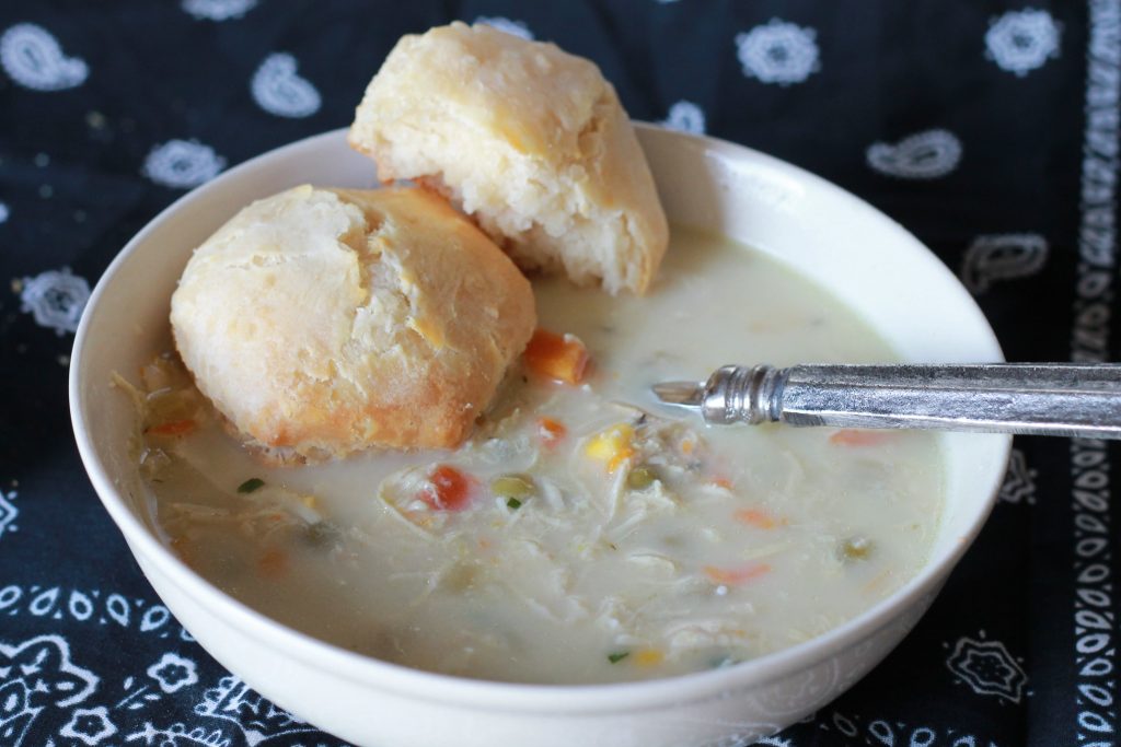 slow cooked chicken with chopped carrots, corn and broth mixed with greek yogurt to create a creamy chicken pot pie soup, with a side of biscuits.