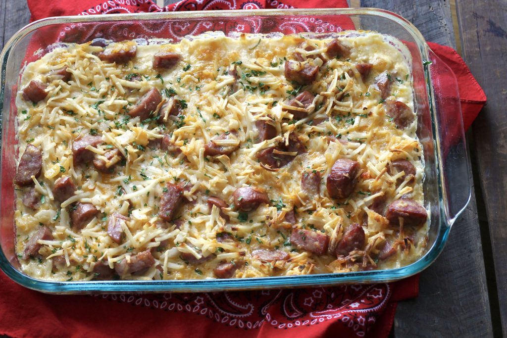 a glass baking dish with baked cheesy sausage hashbrown casserole.