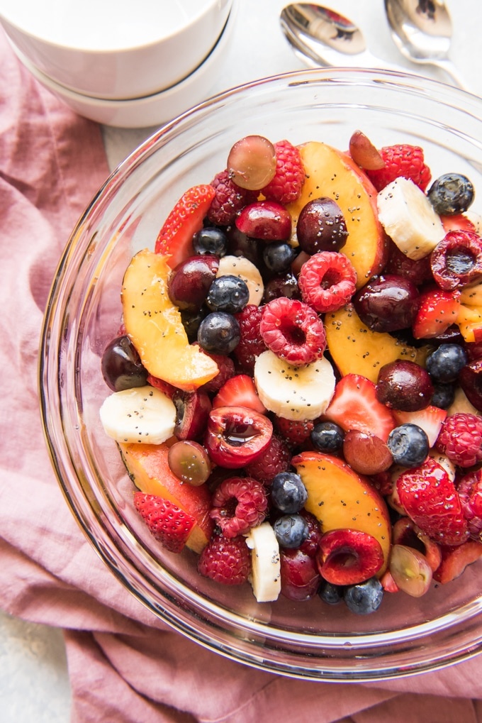 Fruit salad with strawberries, raspberries, peaches, and blueberries.