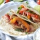 slow cooker chicken fajitas with yellow and red bell peppers in flour tortillas on a white plate