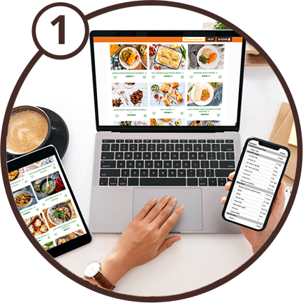 1 - Picture of a left hand using a laptop and right hand holding a mobile phone. Both devices are running the 5 Dinners 1 Hour app.